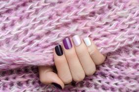 Piurple nail design. Beautiful female hand with different shades of purple manicure