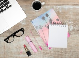 vista-superior-computadora-portatil-lapiz-labial-resaltador-bloc-notas-espiral-taza-cafe-boligrafo-gafas-mesa-oficina-madera_23-2148080384